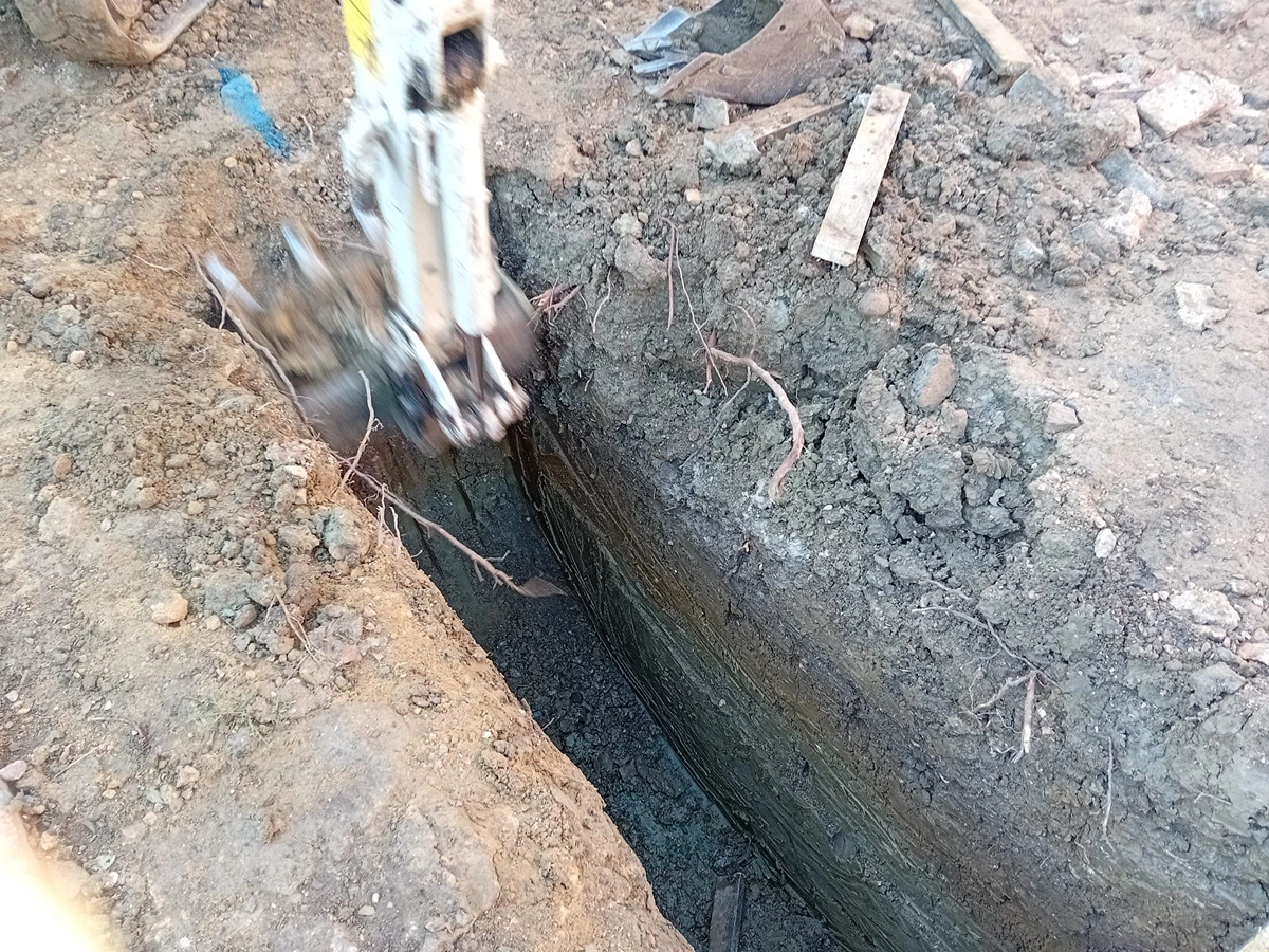 Digger clawing trench for foundation